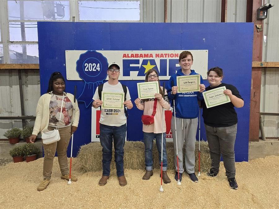 Five students stand proudly holding certificates at the Alabama National Fair.